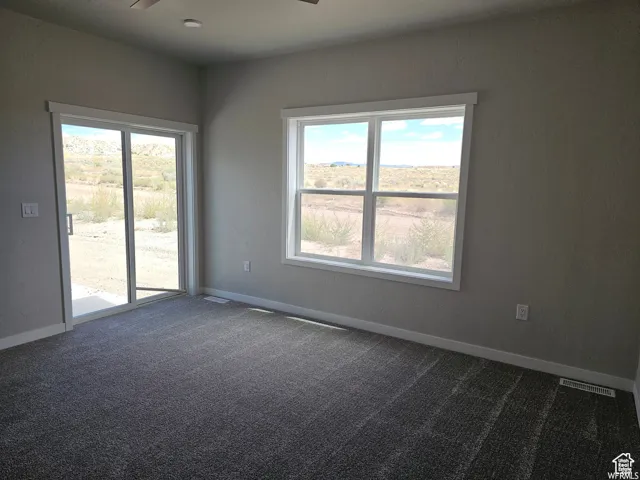 Carpeted empty room featuring ceiling fan