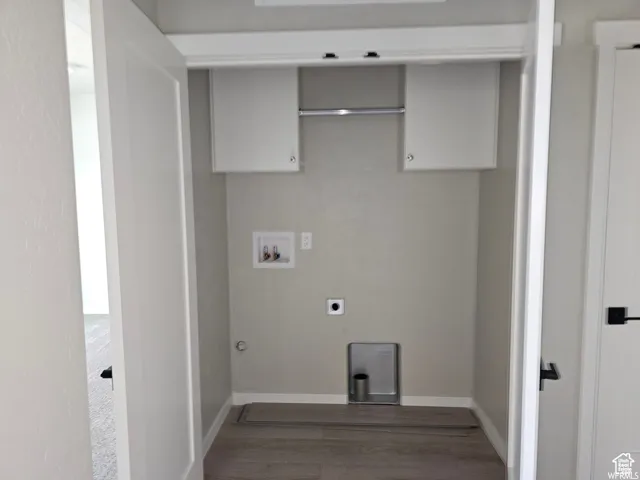 Washroom with washer hookup, hookup for an electric dryer, gas dryer hookup, and dark wood-type flooring