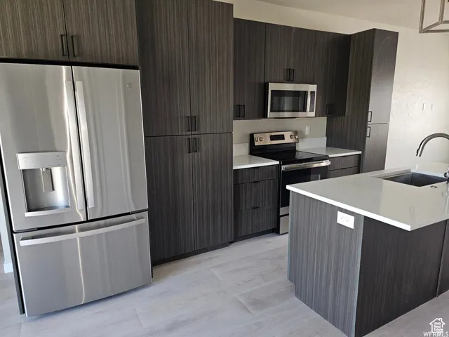 Kitchen featuring sink, dark brown cabinetry, and stainless steel appliances