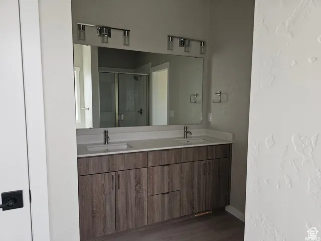 Bathroom with vanity, an enclosed shower, and hardwood / wood-style flooring