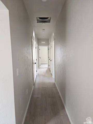 Hallway with hardwood / wood-style flooring