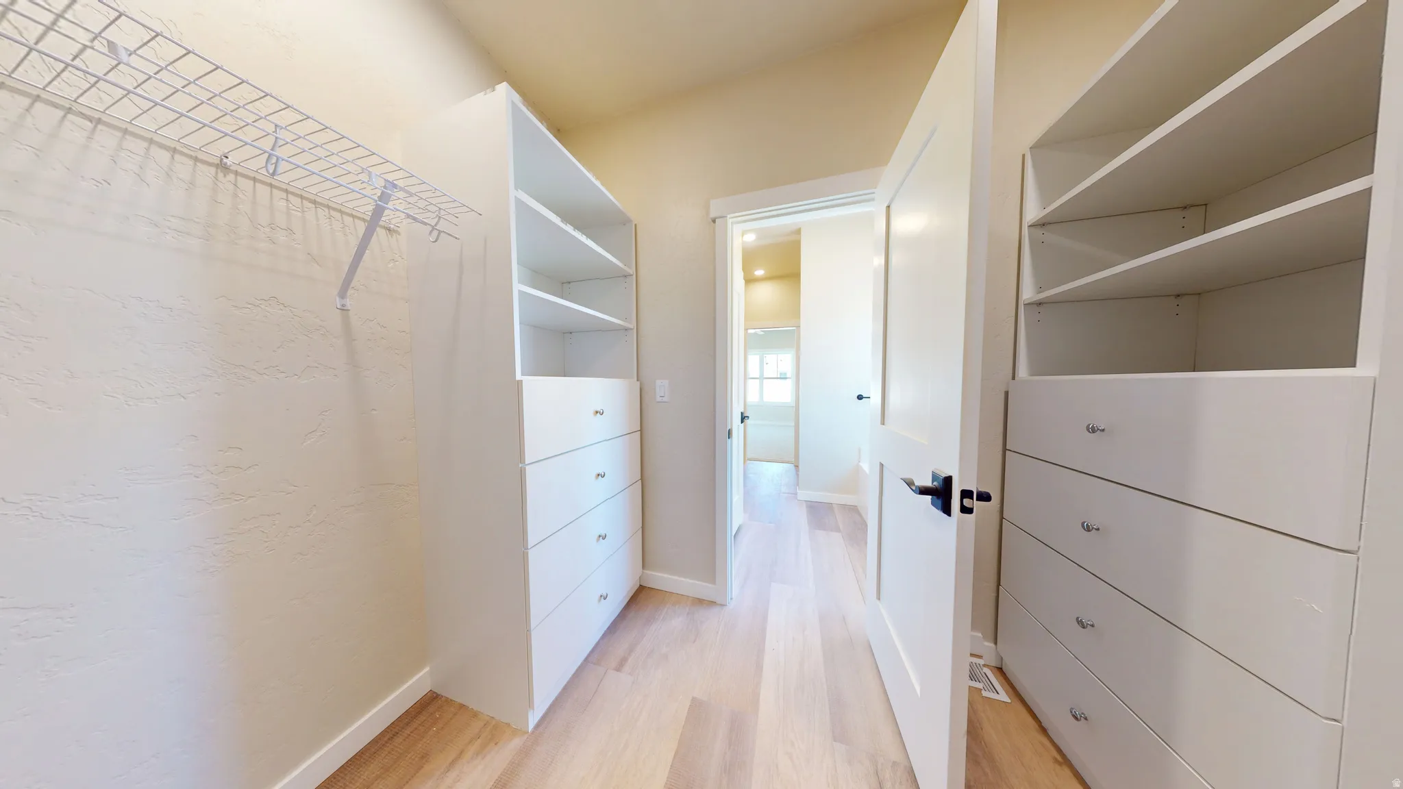 Spacious closet with light wood-style flooring