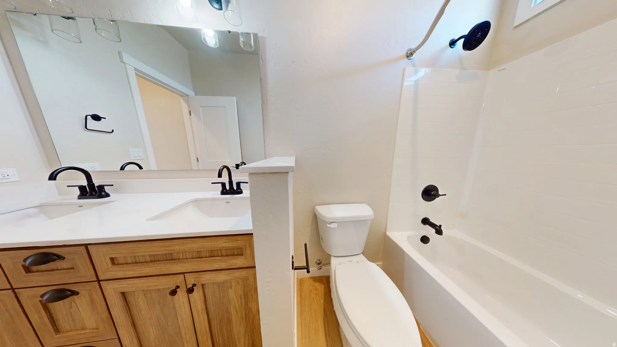 Bathroom featuring double vanity and shower / bathtub combination