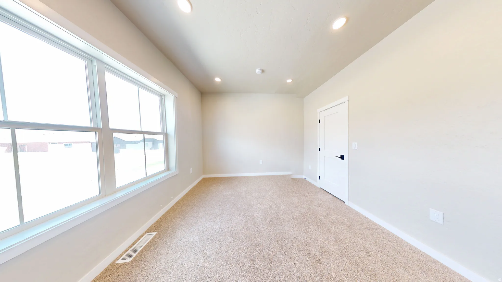 Empty room featuring light carpet and recessed lighting