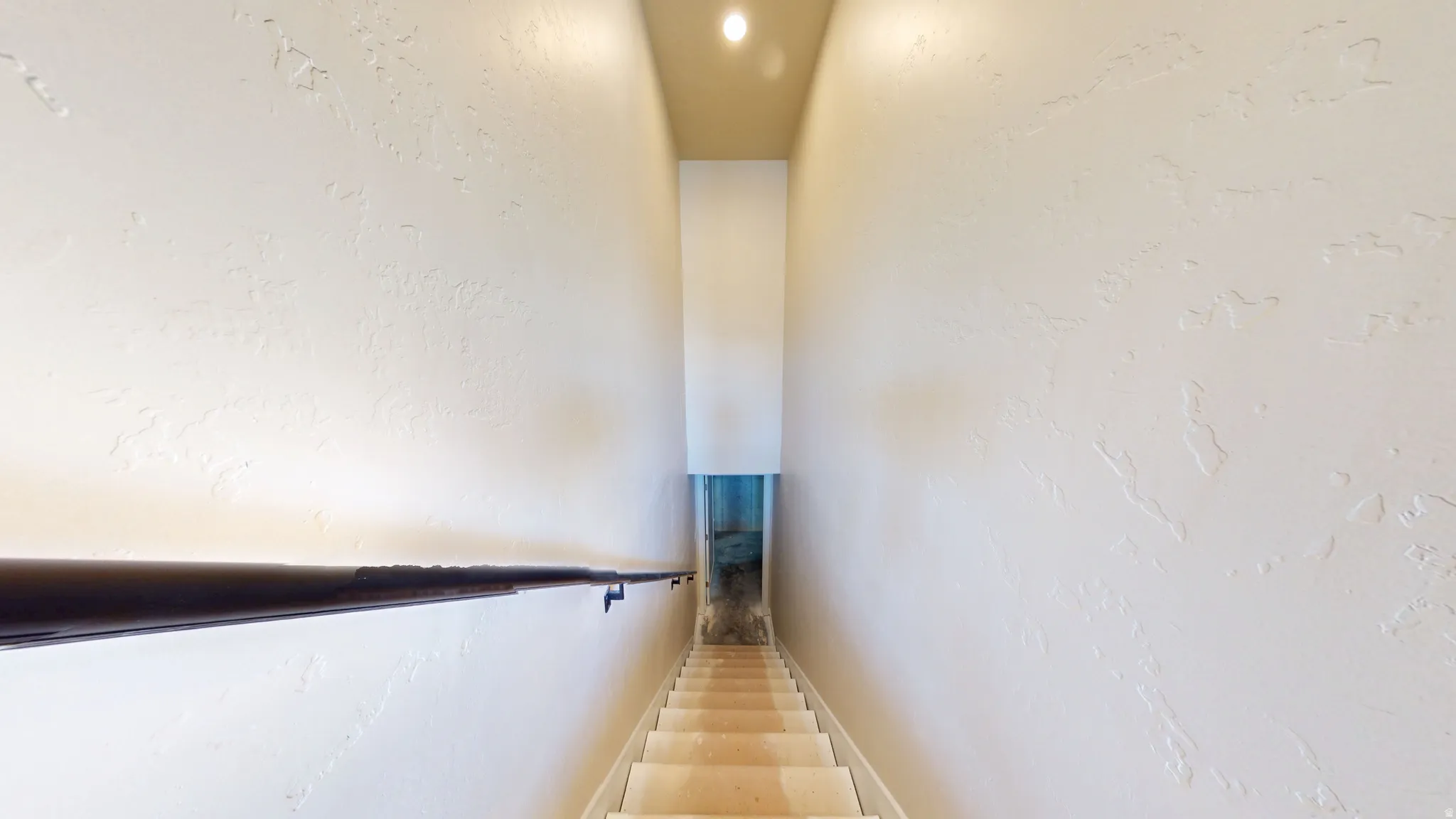 Stairway featuring a textured wall