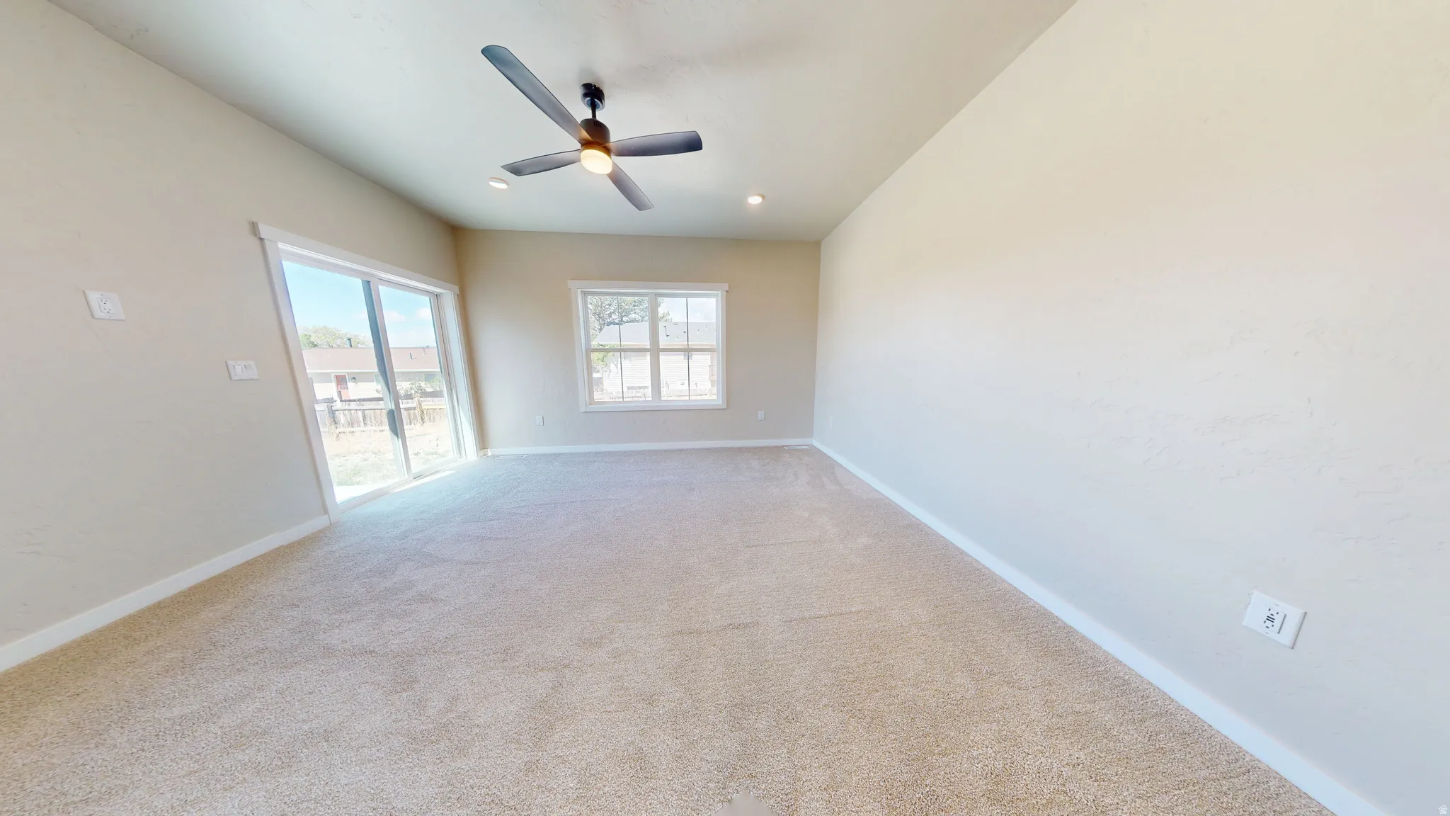 Carpeted spare room featuring ceiling fan and recessed lighting