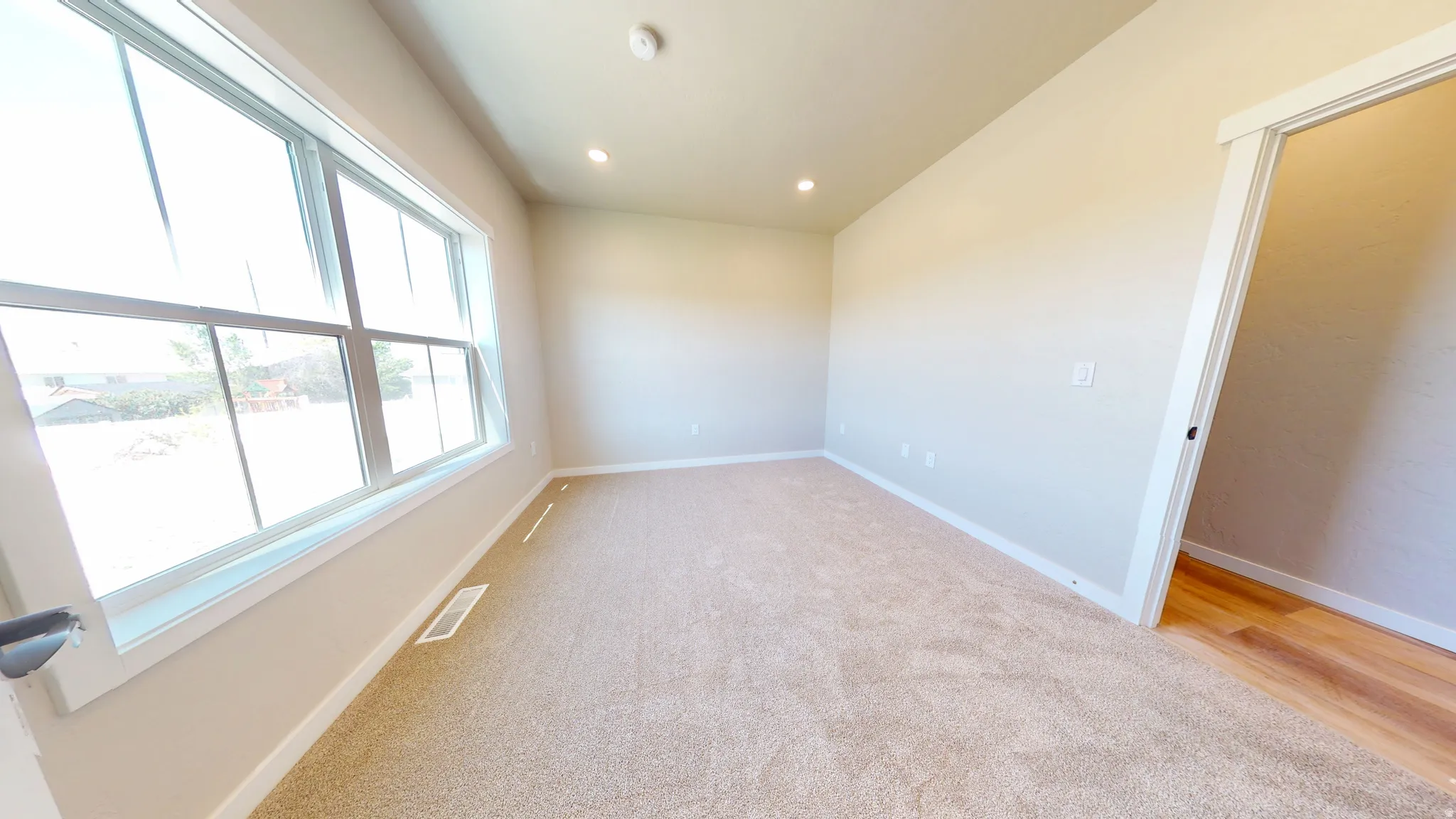 Empty room featuring light carpet and recessed lighting