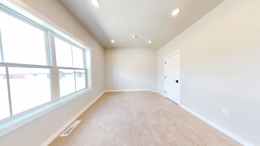 Empty room featuring light carpet and recessed lighting