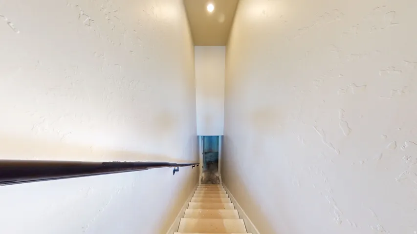 Stairway featuring a textured wall