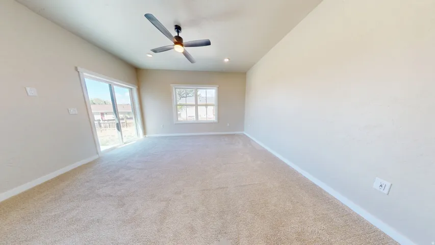 Carpeted spare room featuring ceiling fan and recessed lighting