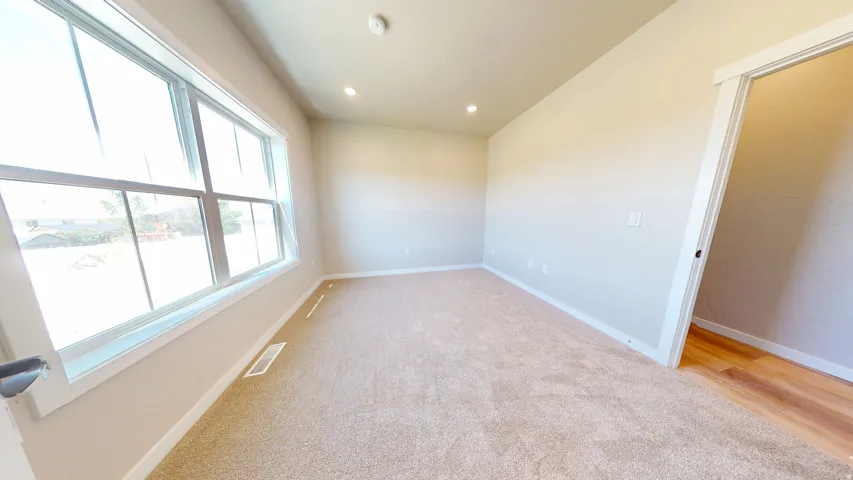 Empty room featuring light carpet and recessed lighting