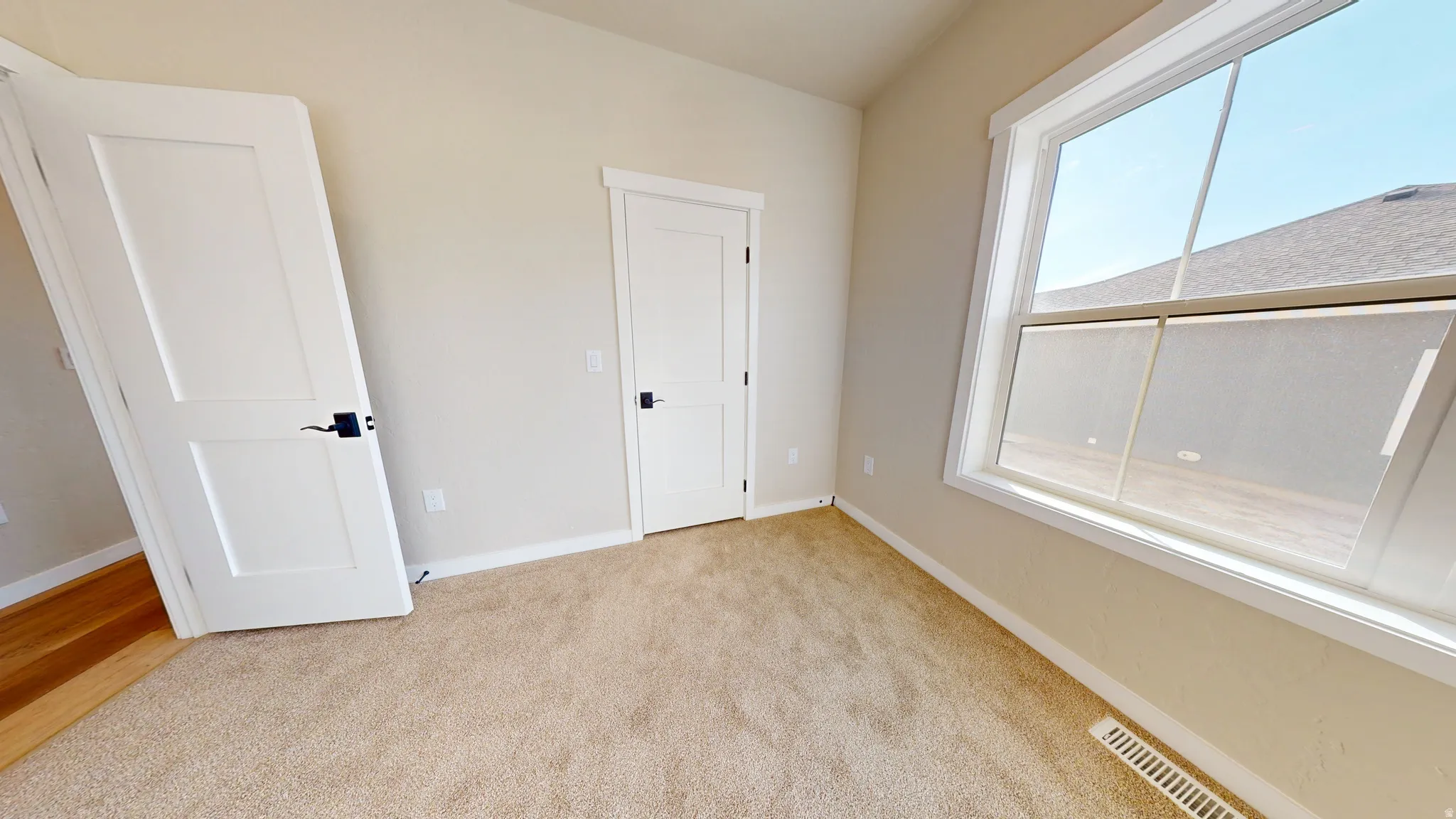 Unfurnished bedroom featuring light carpet and baseboards