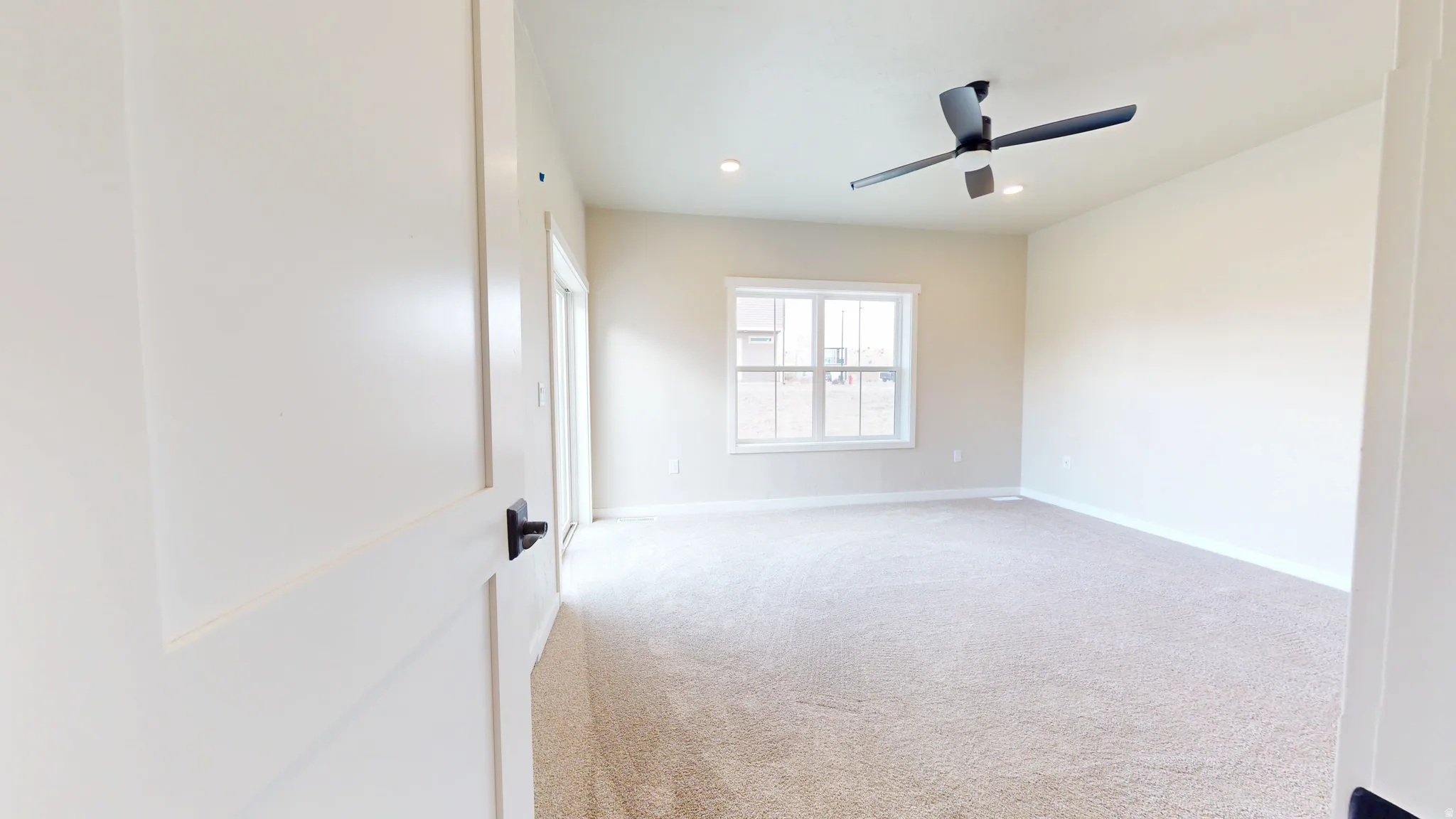 Empty room featuring light colored carpet, recessed lighting, and a ceiling fan