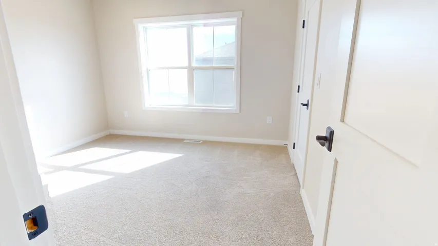 Empty room featuring light carpet and baseboards