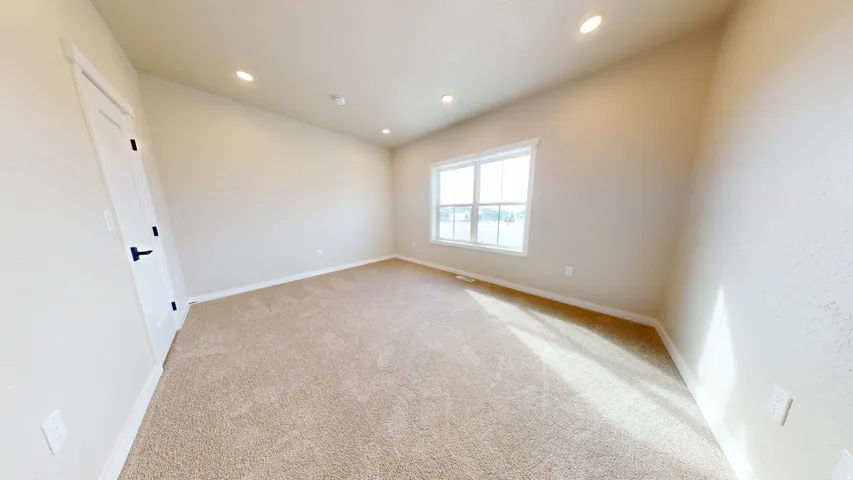 Spare room featuring light colored carpet, recessed lighting, and lofted ceiling