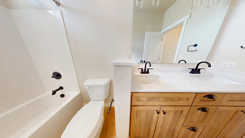 Full bath featuring double vanity and shower / bath combination
