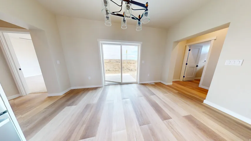 Unfurnished dining area featuring a chandelier and light wood finished floors