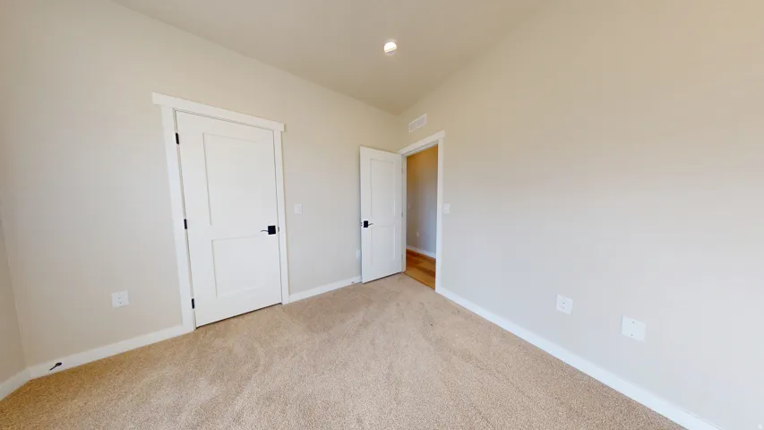 Unfurnished bedroom featuring carpet flooring, recessed lighting, and lofted ceiling
