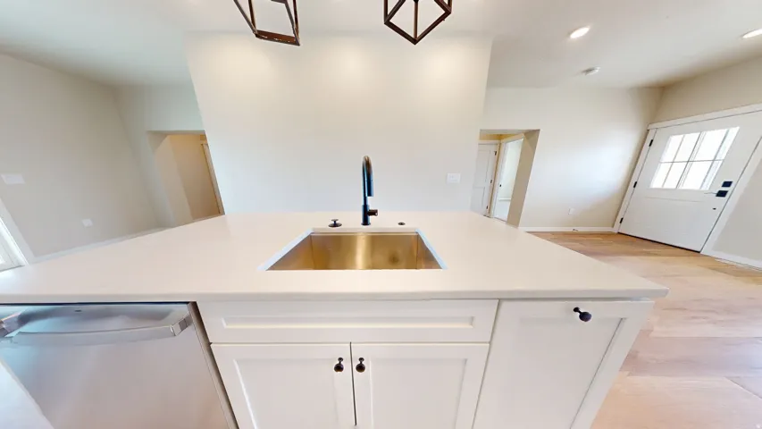 Kitchen with a kitchen island with sink, stainless steel dishwasher, white cabinets, recessed lighting, and light wood-type flooring