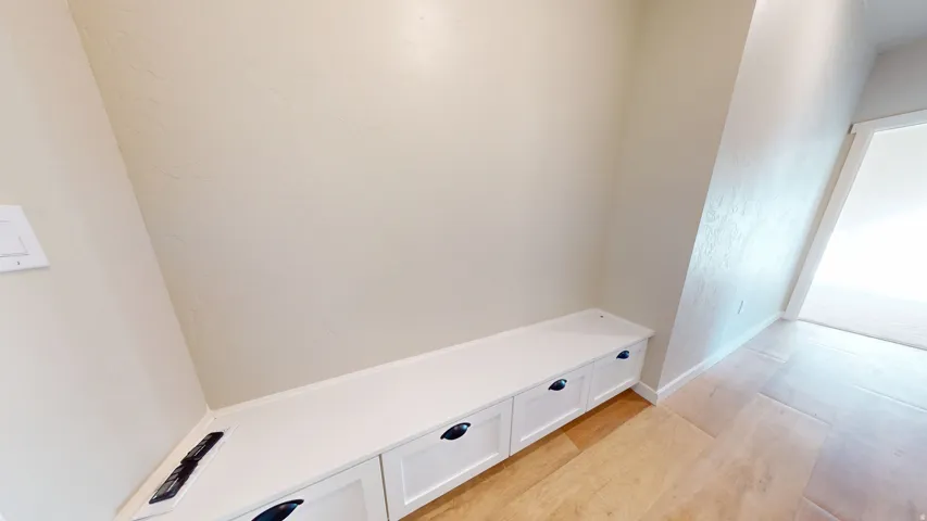 Mudroom with light wood-style floors and a textured wall