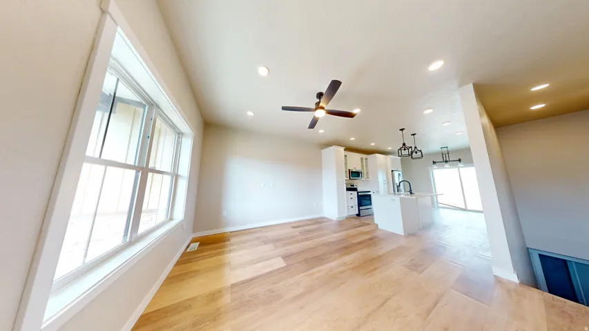 Unfurnished living room featuring light wood-style floors, recessed lighting, and a ceiling fan