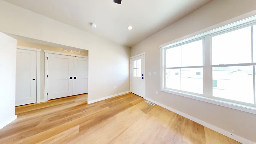 Entryway with light wood-style flooring, lofted ceiling, and recessed lighting