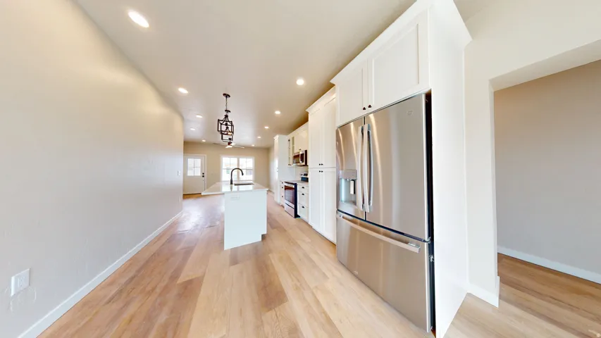 Kitchen with stainless steel appliances, recessed lighting, a kitchen island with sink, pendant lighting, and white cabinets