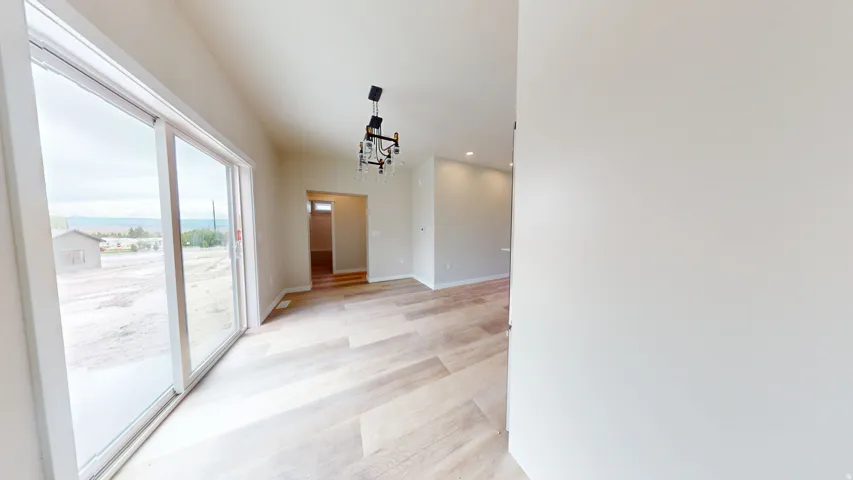 Corridor with a chandelier, light wood-type flooring, and recessed lighting
