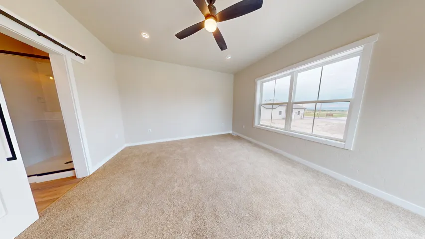 Unfurnished room with light carpet, recessed lighting, a ceiling fan, and a barn door