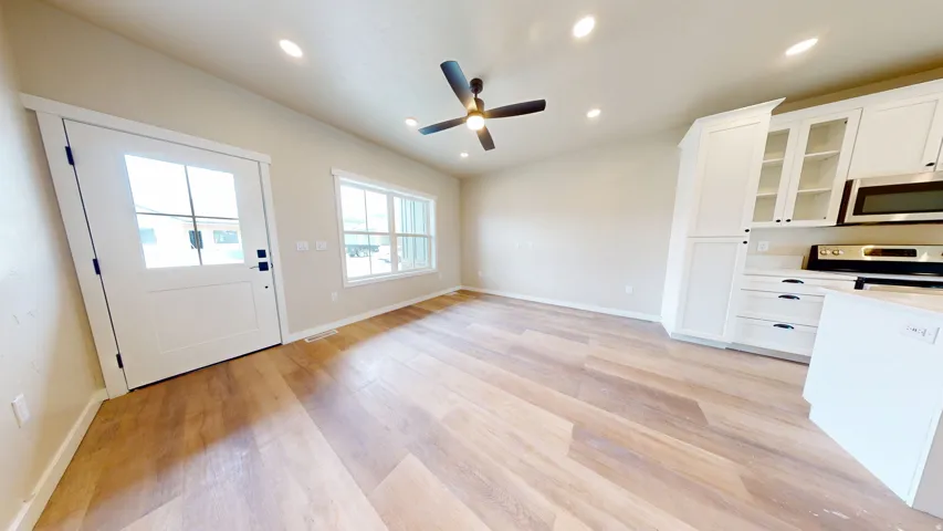 Kitchen featuring glass insert cabinets, white cabinetry, recessed lighting, appliances with stainless steel finishes, and light wood-style flooring