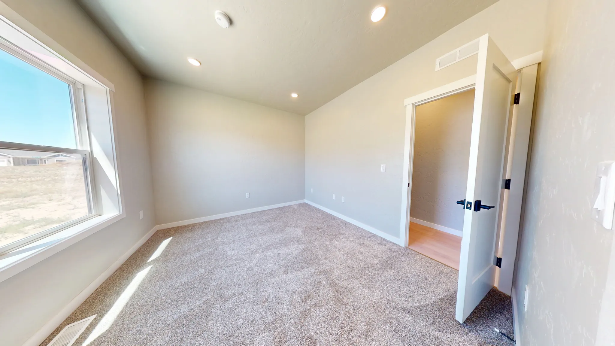 Spare room featuring light colored carpet, recessed lighting, and lofted ceiling