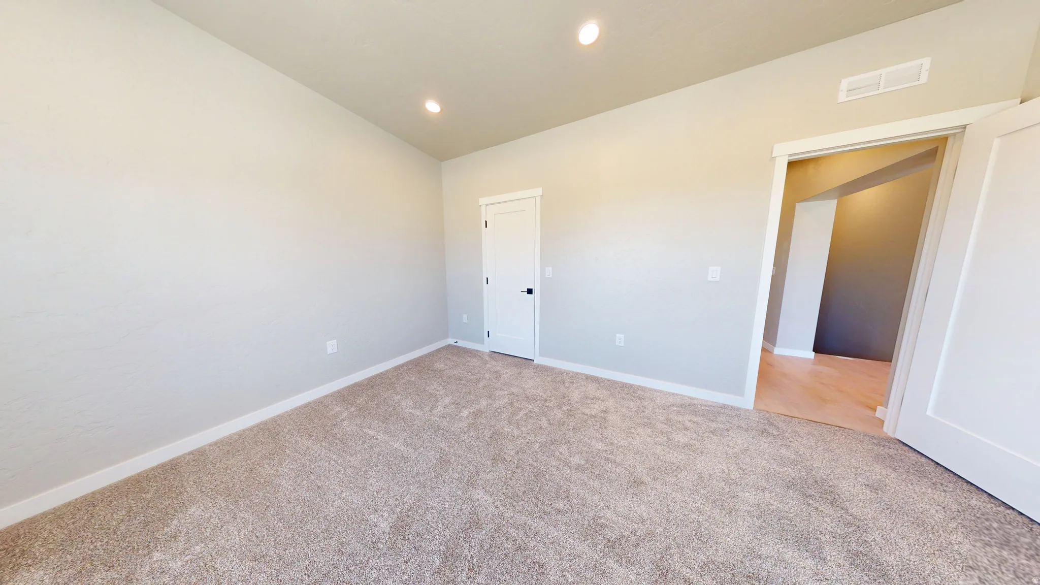 Unfurnished bedroom with recessed lighting, carpet flooring, and vaulted ceiling