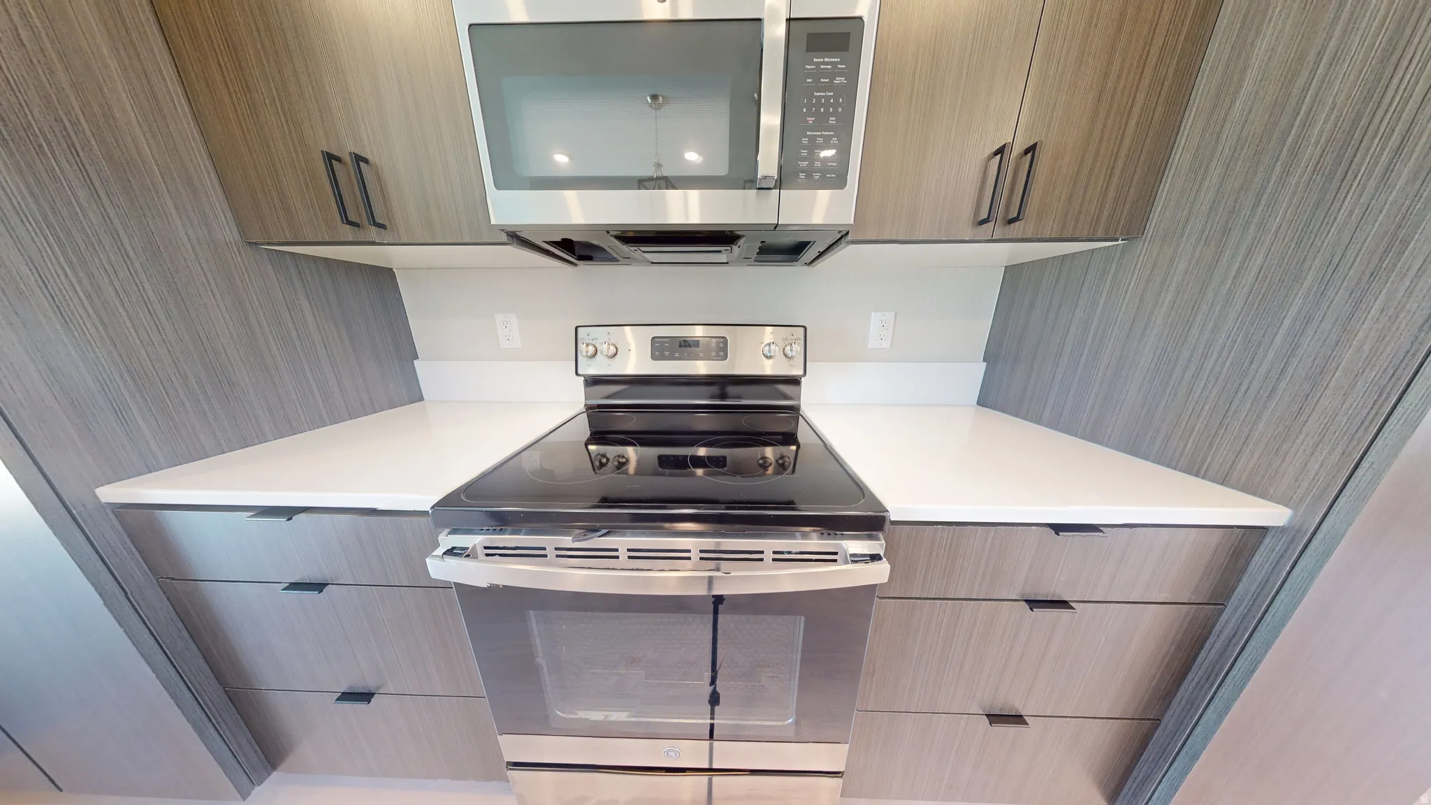 Kitchen featuring stainless steel appliances, light countertops, and modern cabinets
