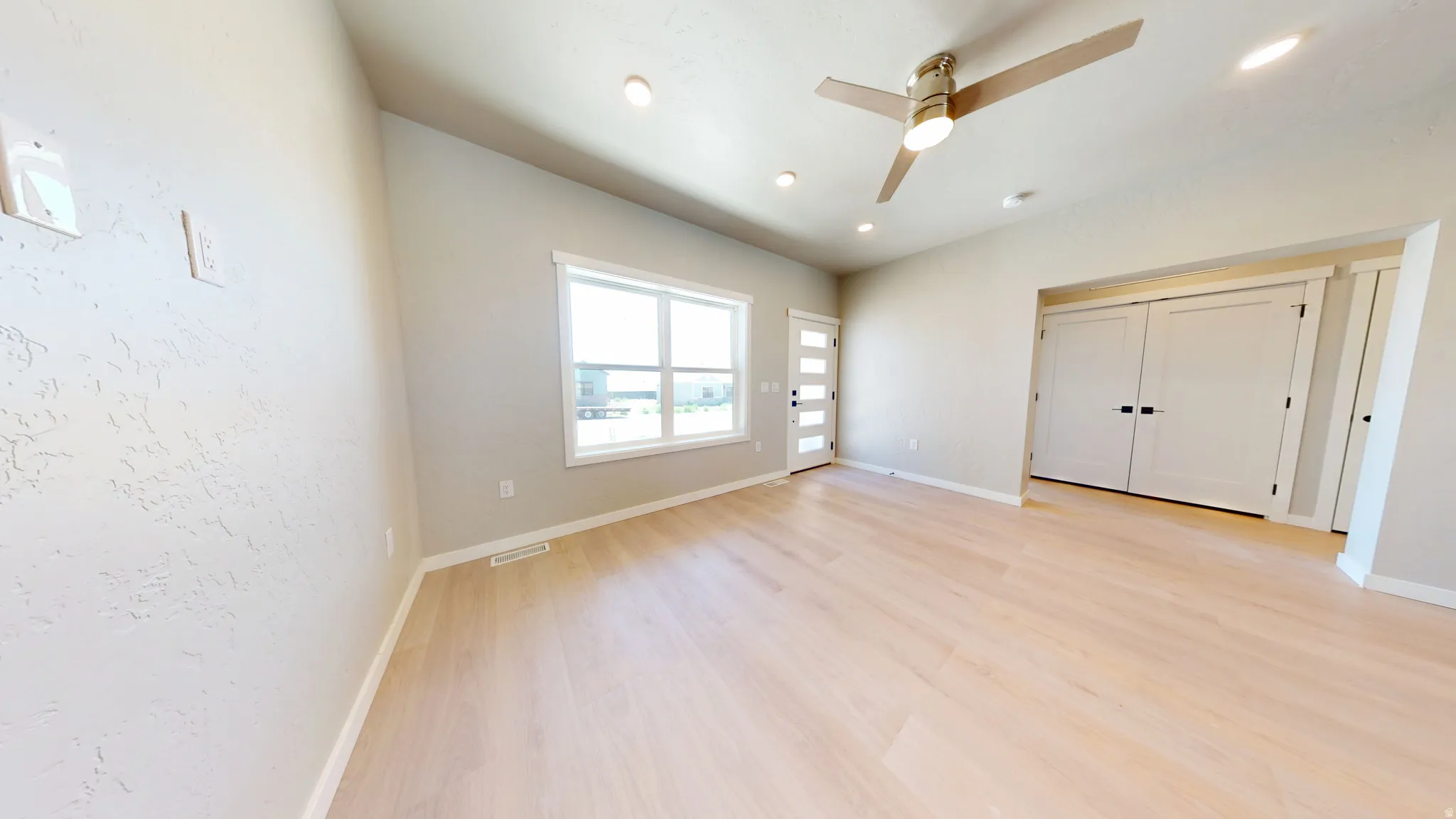 Unfurnished living room featuring light wood finished floors, ceiling fan, a closet, and recessed lighting