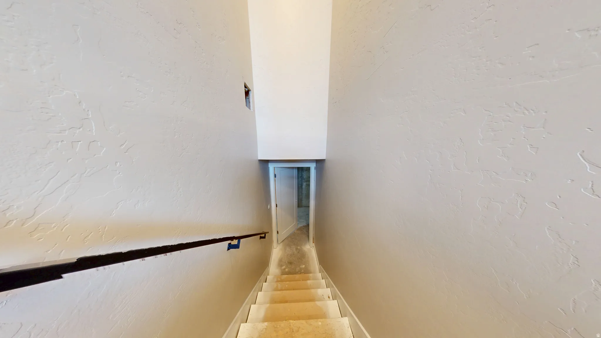 Staircase featuring a textured wall