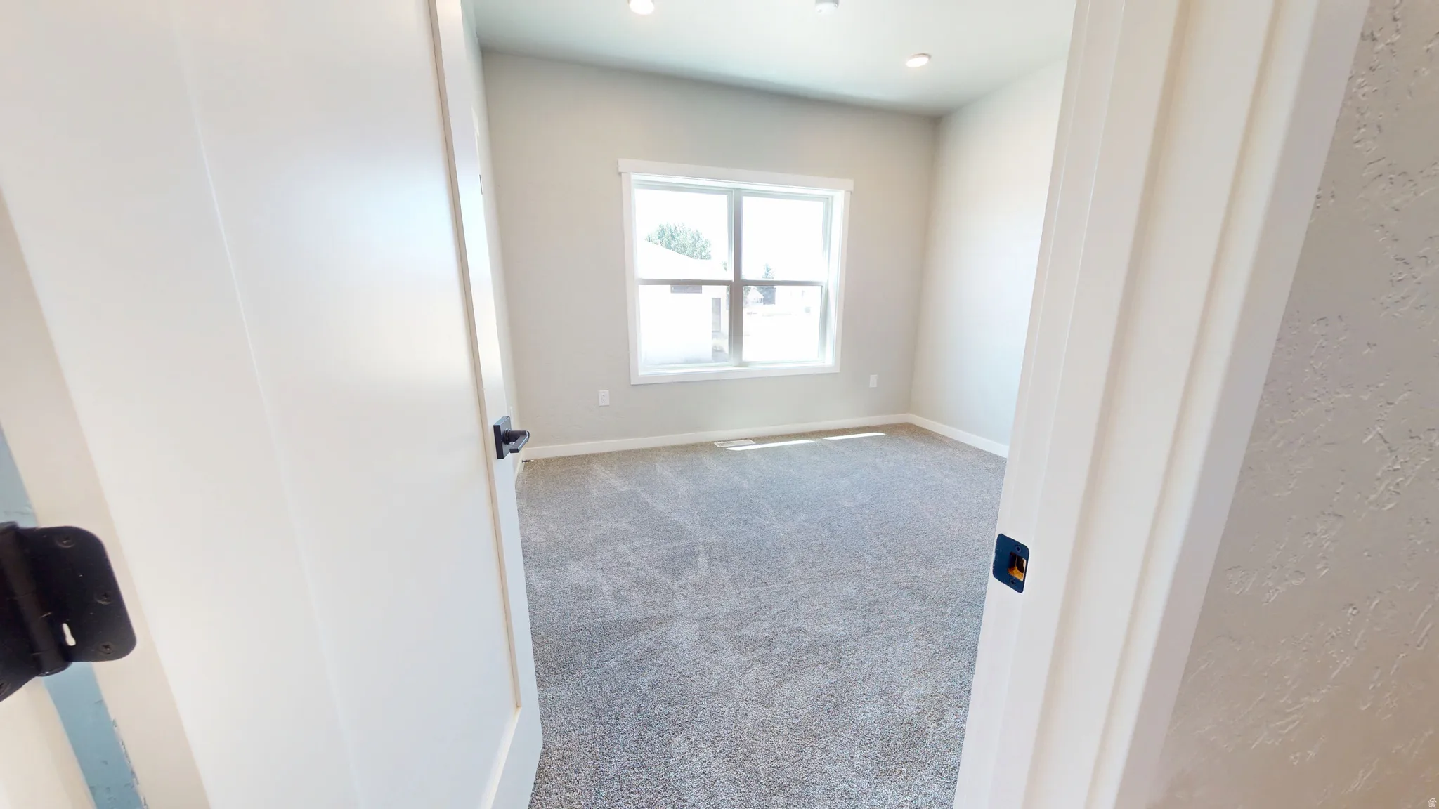 Carpeted empty room with baseboards