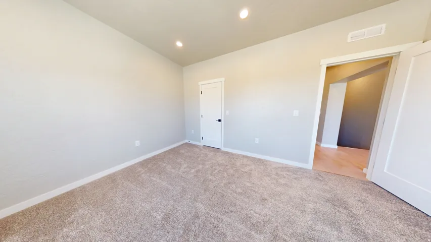 Unfurnished bedroom with recessed lighting, carpet flooring, and vaulted ceiling