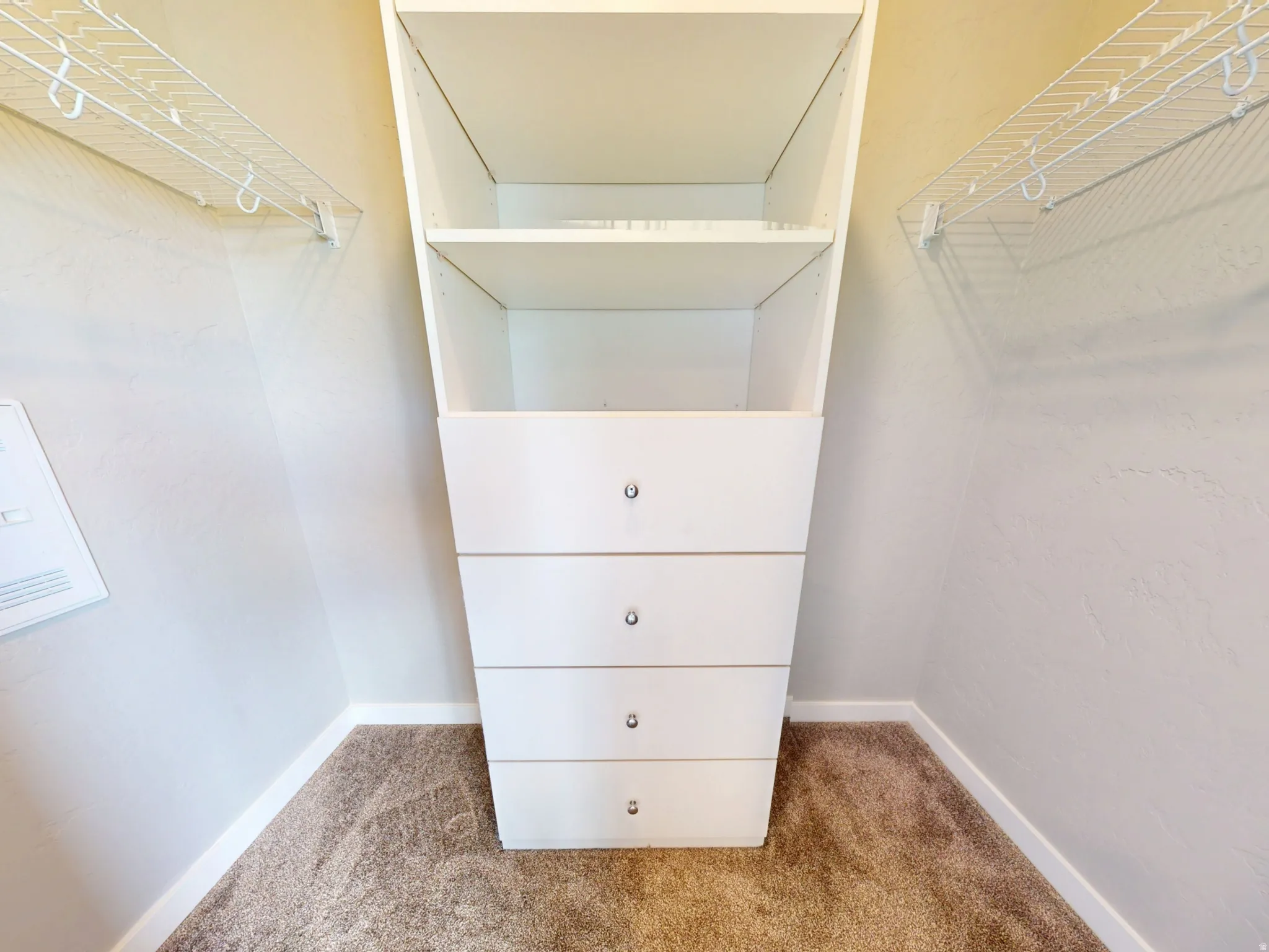 Spacious closet with light colored carpet
