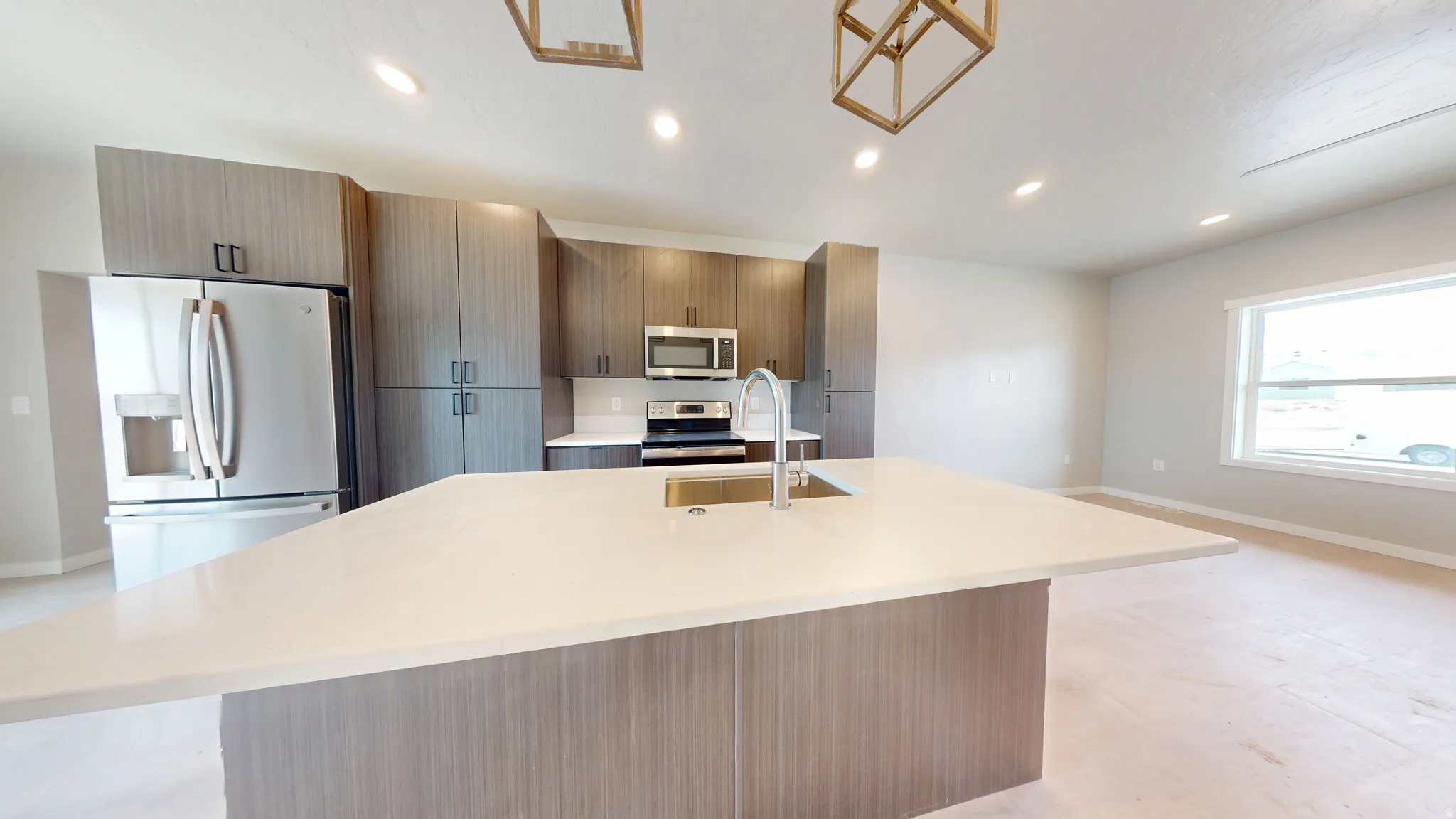 Kitchen featuring stainless steel appliances, recessed lighting, a center island with sink, light stone countertops, and modern cabinets