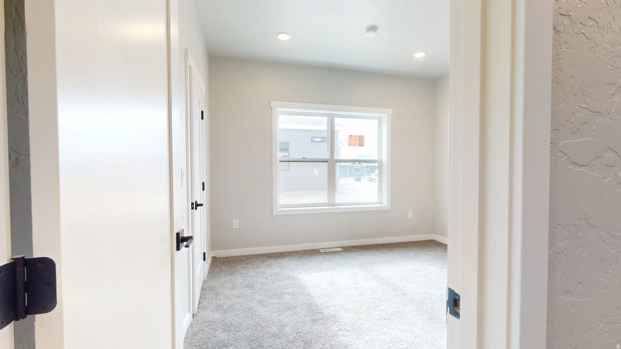 Spare room featuring carpet and baseboards