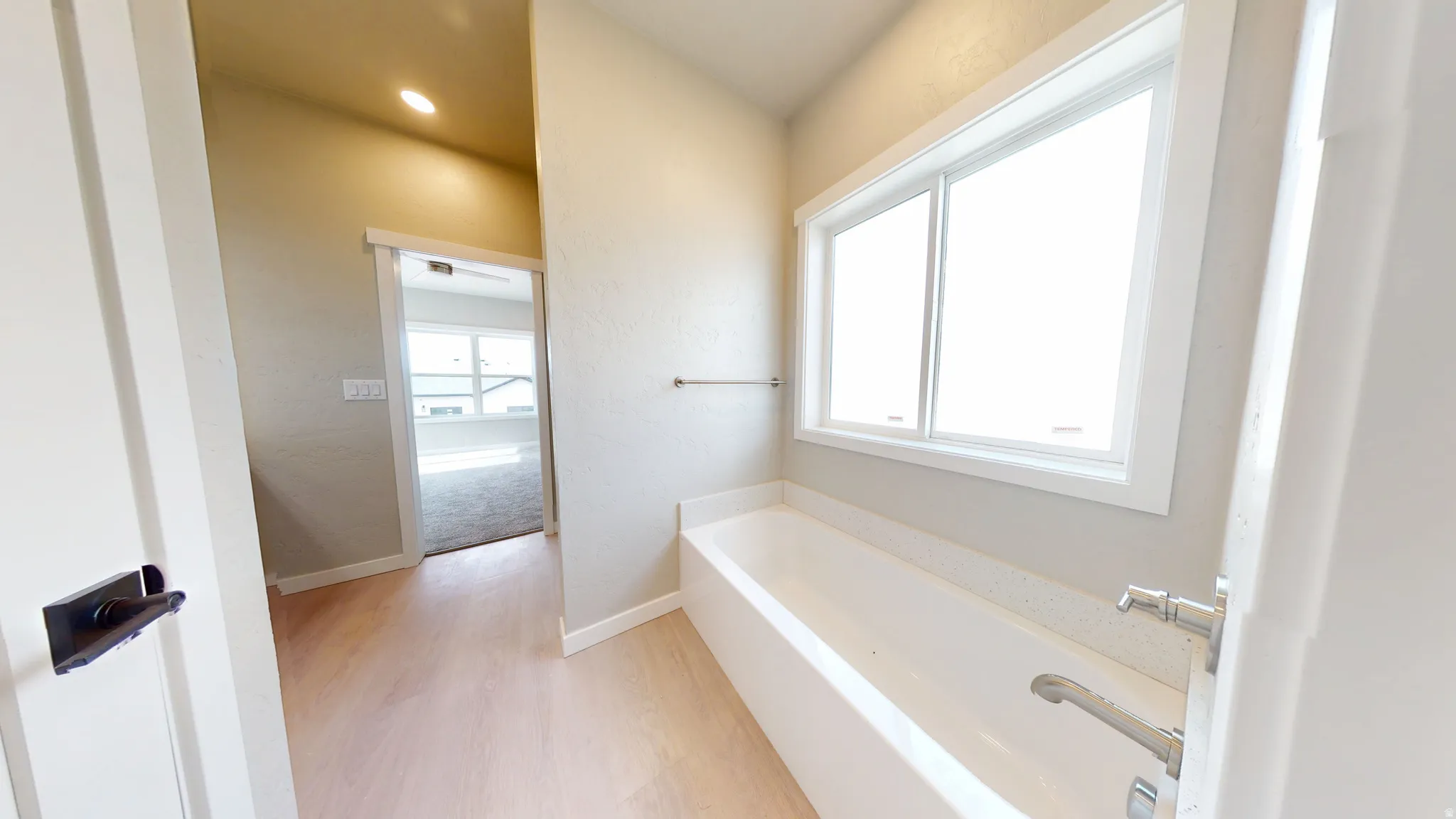 Bathroom with a bath and light wood-style flooring
