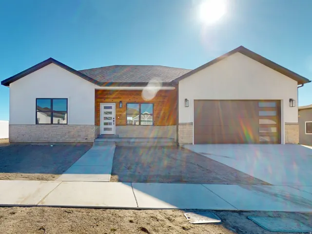 Contemporary house with stone siding, stucco siding, an attached garage, and driveway