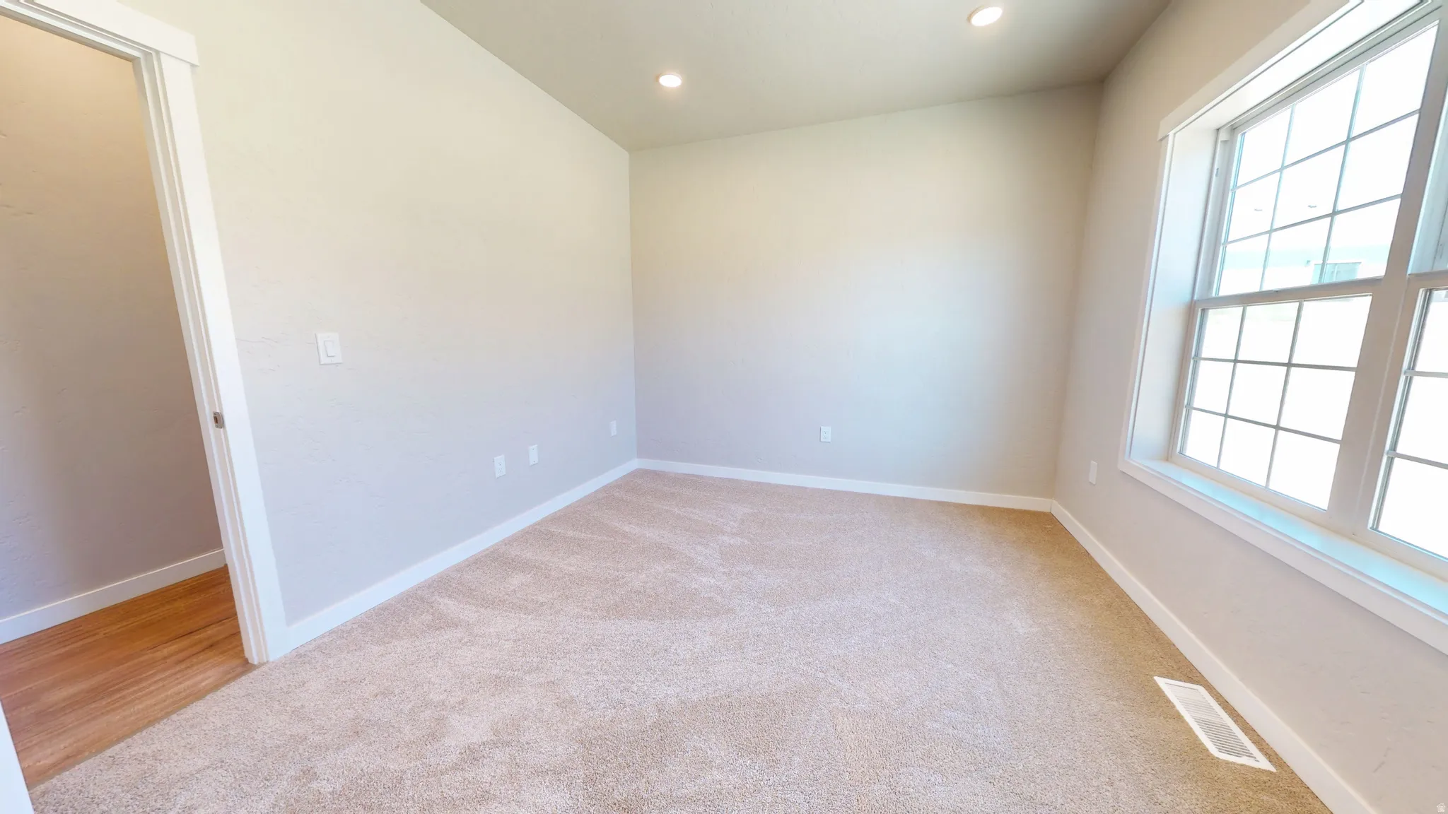 Spare room with recessed lighting and light carpet