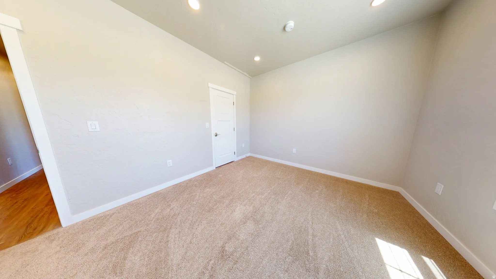 Unfurnished room featuring lofted ceiling, light carpet, and recessed lighting
