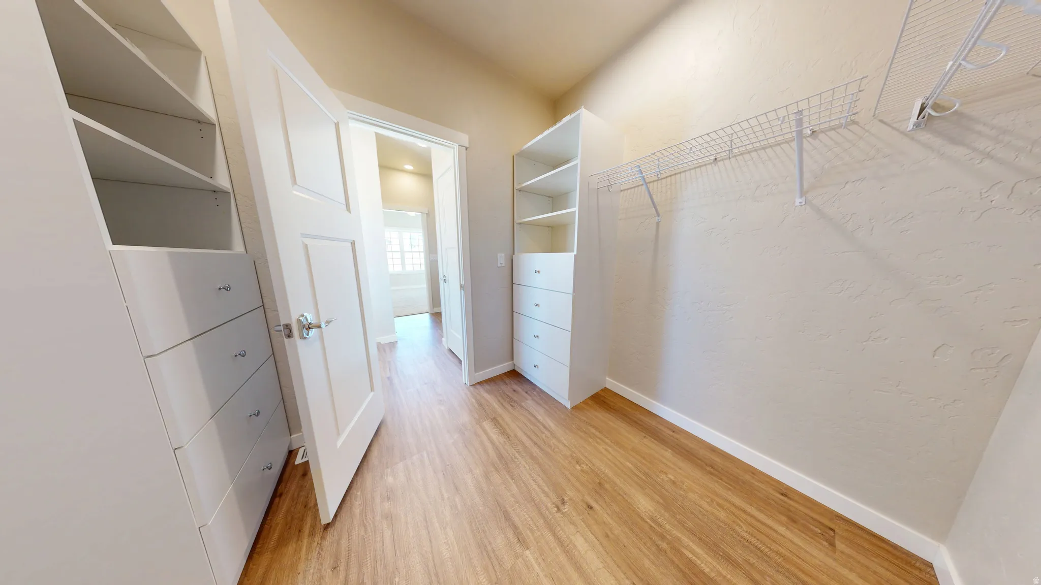 Walk in closet featuring light wood-style floors
