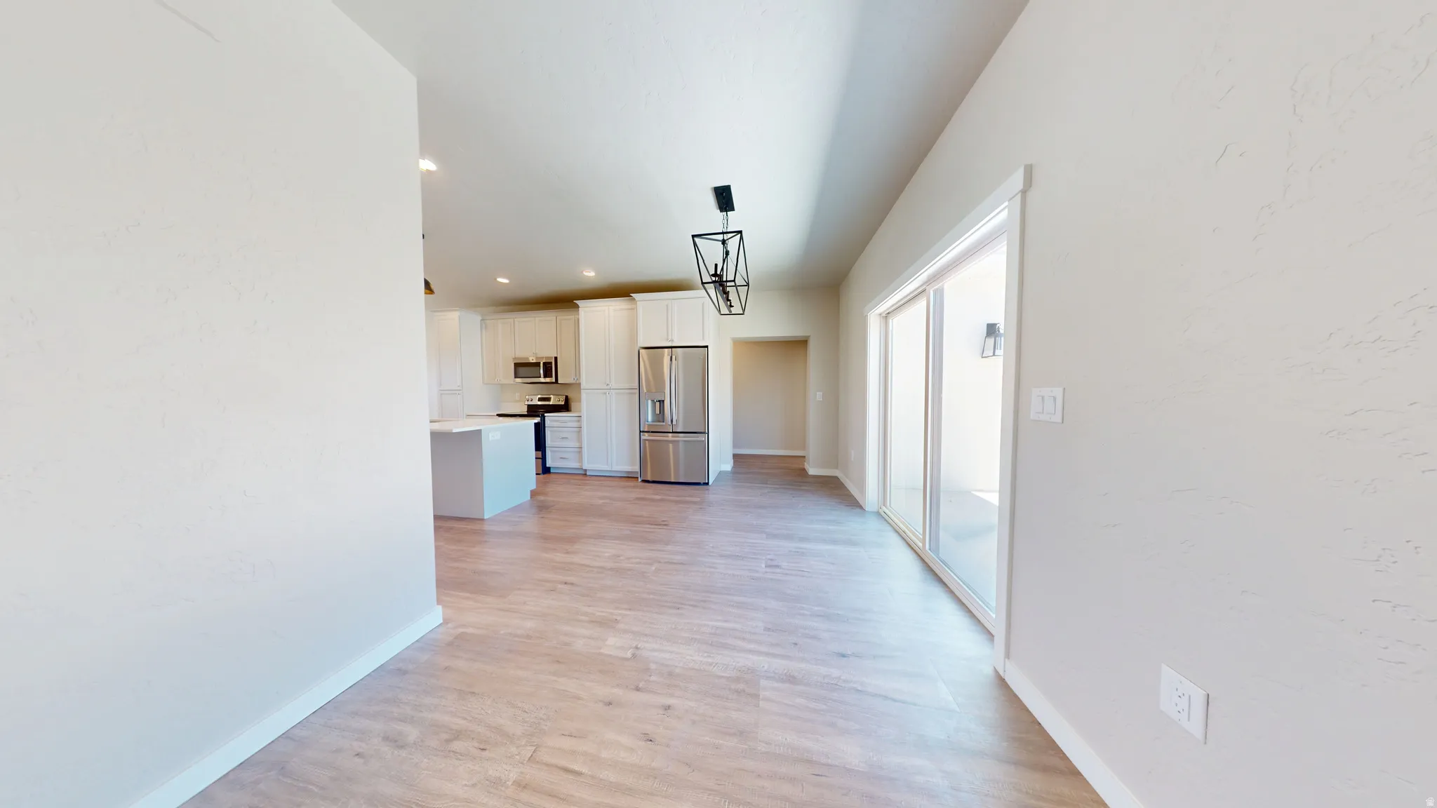 Hallway with light wood-style floors and recessed lighting