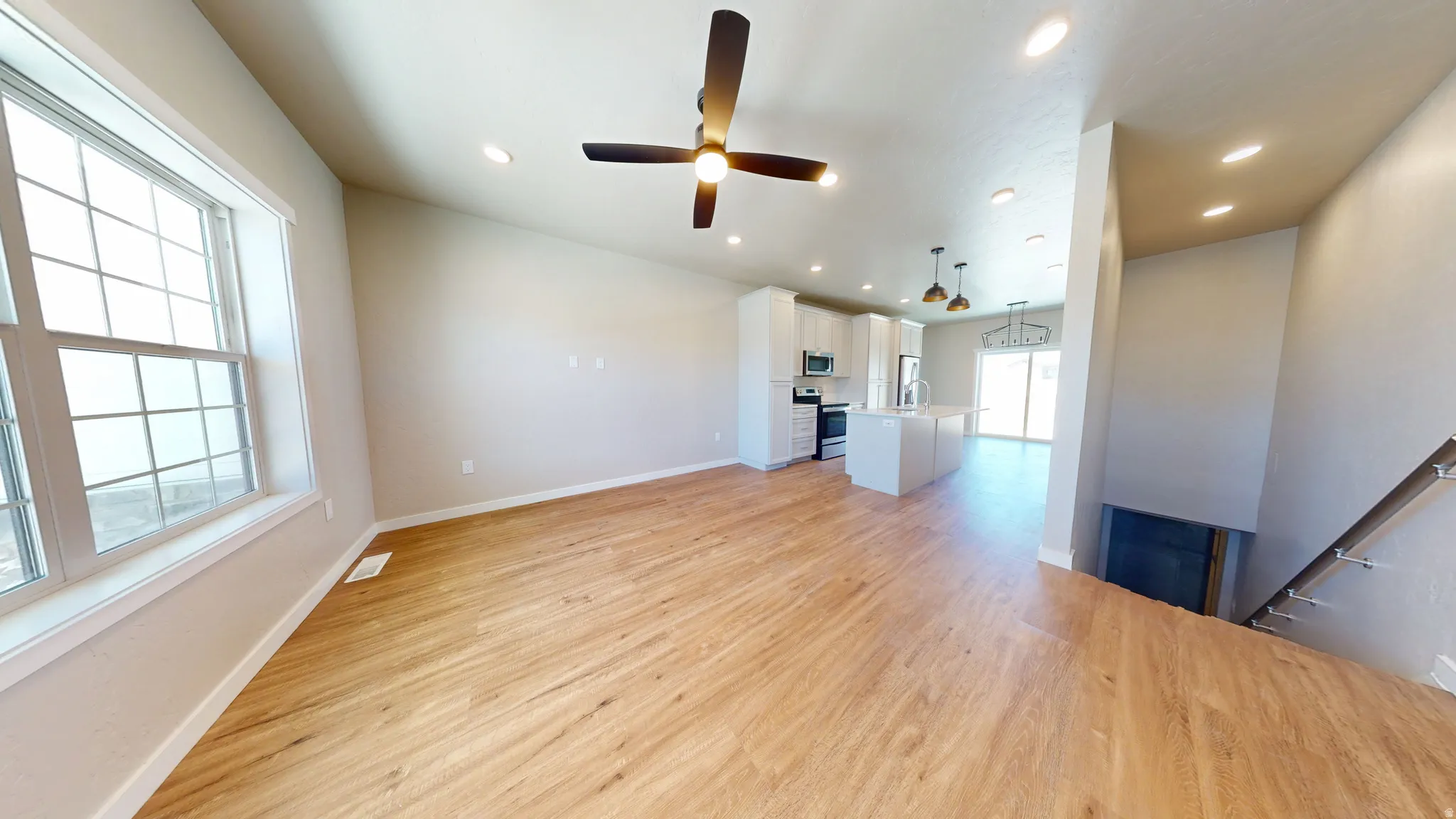Unfurnished living room featuring ceiling fan, light wood-style floors, and recessed lighting
