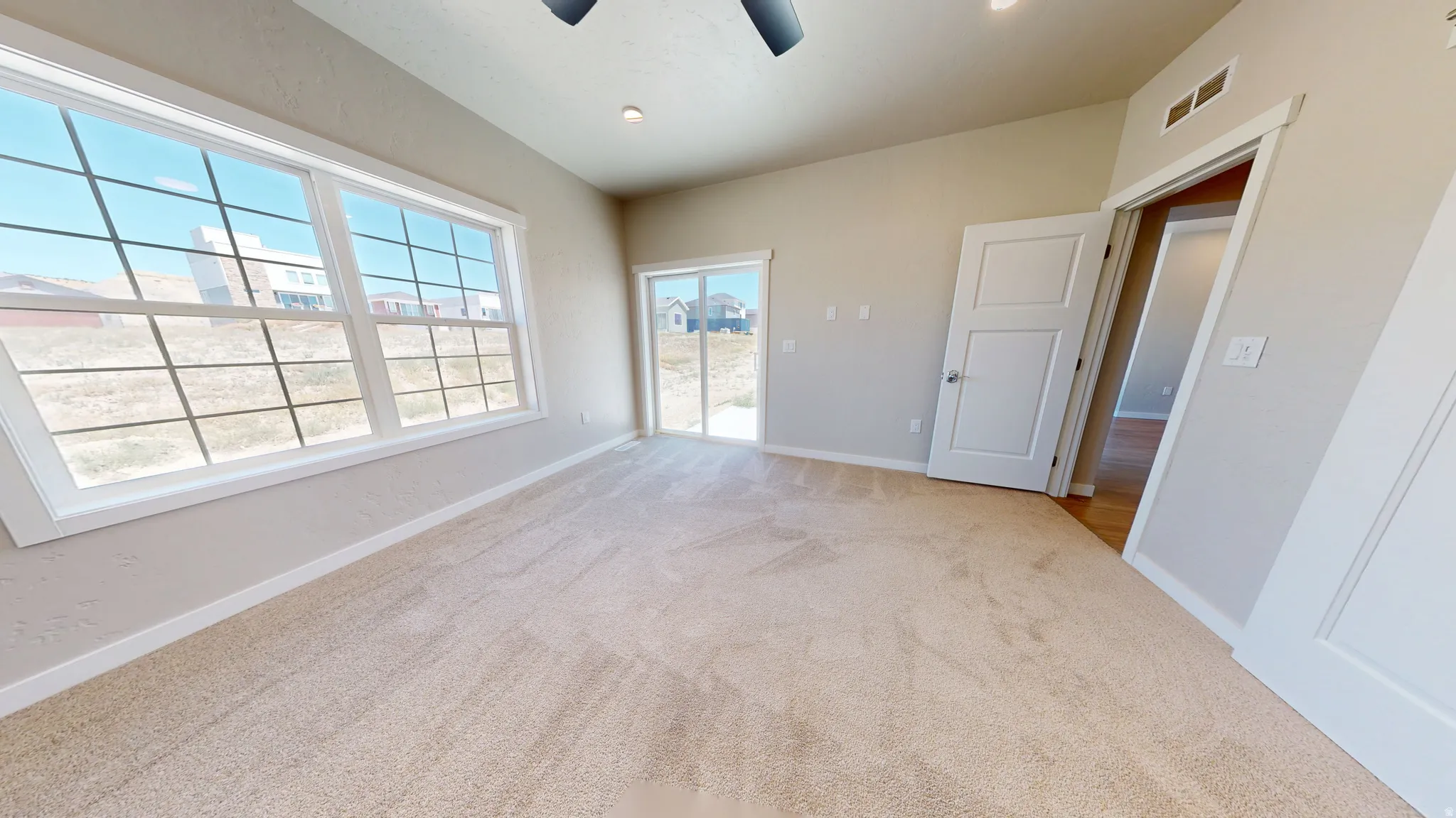 Unfurnished bedroom with light carpet, access to outside, and ceiling fan