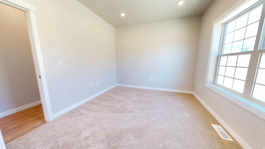 Spare room with recessed lighting and light carpet