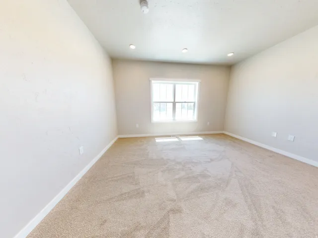 Empty room featuring light colored carpet and recessed lighting